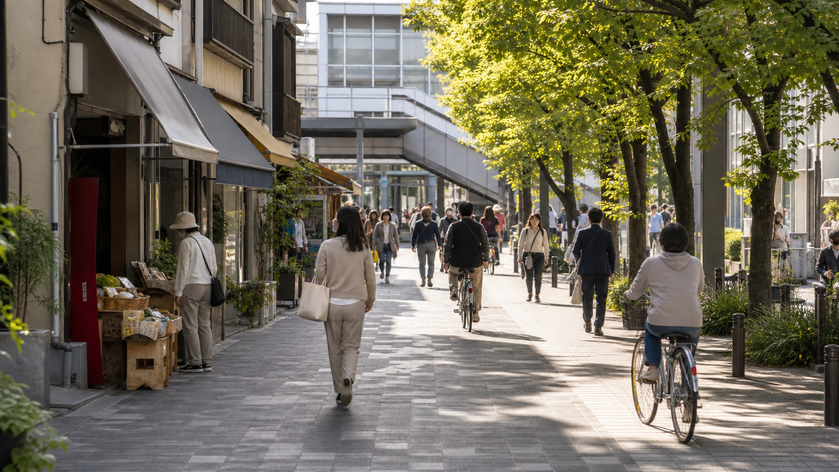 街路樹のある駅前通りを人々が歩く活気ある商店街の風景